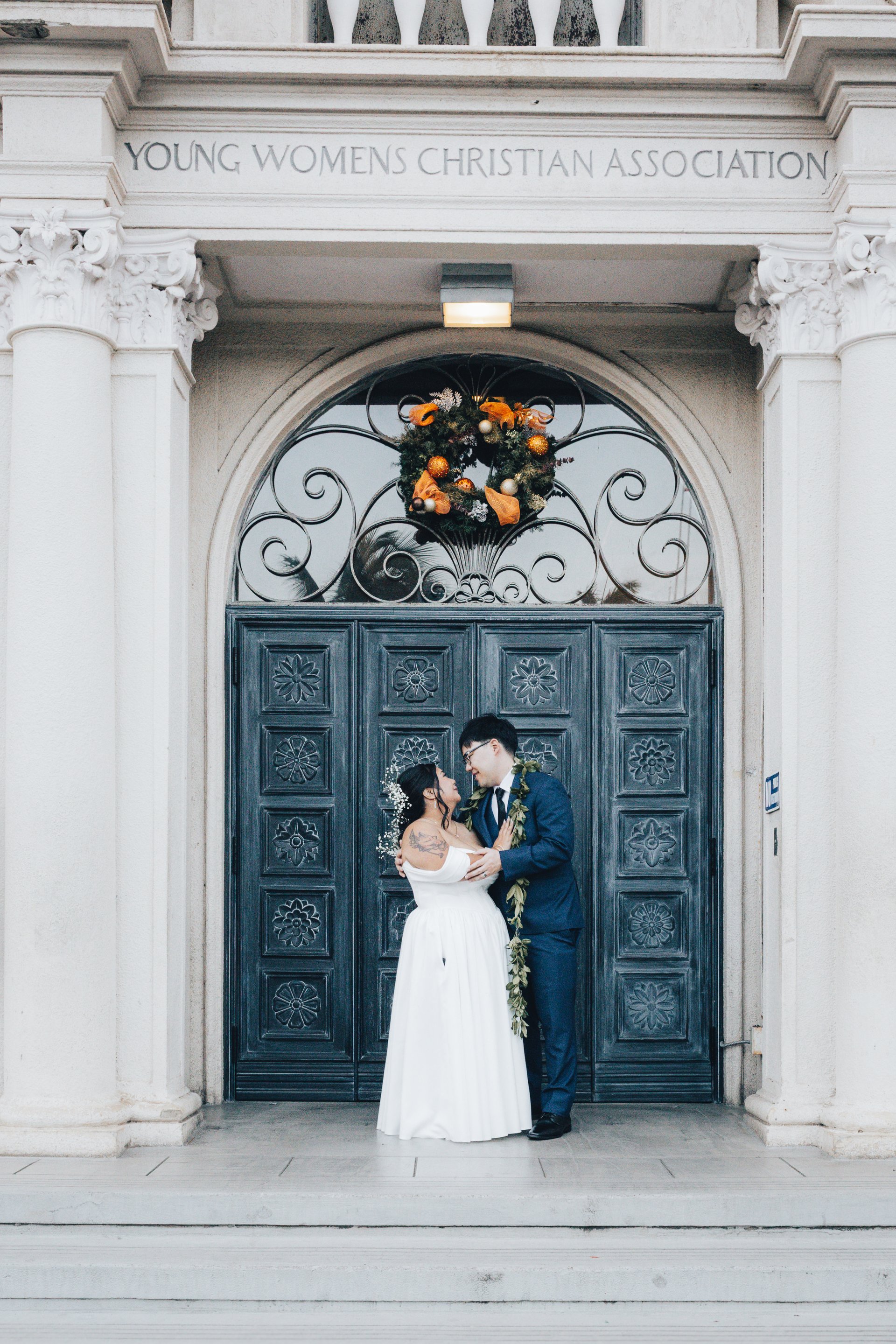 Bride and groom portrait on balcony overlooking pool at historic Hawaii wedding venue